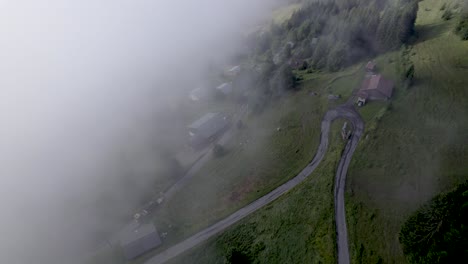 Luftaufnahme-Des-Berghangs-Des-Mont-Chery-Mit-Grünen-Wiesen-Und-Kiefern,-Gesehen-Durch-Wolken,-Die-Die-Hälfte-Der-Landschaft-Verdecken