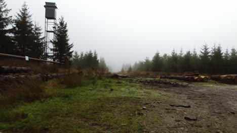 Eine-Drohne-Zieht-Sich-In-Einem-Nebelbedeckten-Wald-Zurück-Und-Gibt-Den-Blick-Auf-Einen-Wachturm-In-Belgien-Frei