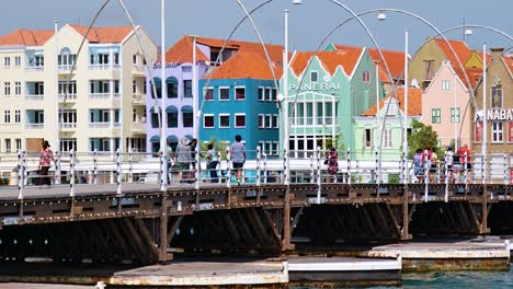 People-crossing-the-Queen-Emma-Bridge-in-Punda,-Willemstad,-on-the-Caribbean-island-of-Curacao