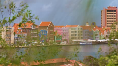 Slow-left-to-right-cinematic-B-roll-slider-pan-of-Willemstad-city-featuring-the-iconic-colorful-world-heritage-UNESCO-buildings-of-the-Handelskade-in-Punda,-Curacao