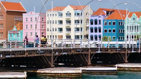 4k-60fps-cinematic-slow-parallax-dolly-pan-of-the-iconic-colorful-world-heritage-UNESCO-buildings-in-Willemstad-and-the-floating-Queen-Emma-Bridge-in-Willemstad,-Curacao