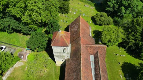 A-top-down-pan-over-St-Lawrence-the-Martyr-church-in-Godmersham,-panning-over-towards-the-graveyard