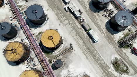Overhead-drone-shot-of-large-industrial-factory-with-oil-storage-tanks-being-prepared-for-refining