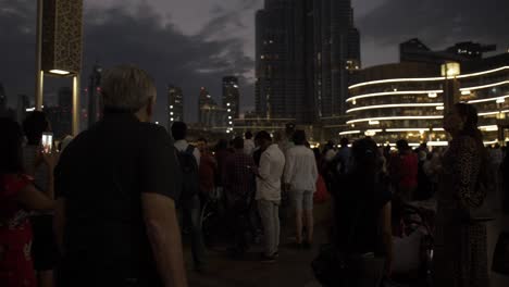 Ein-älterer-Mann,-Der-Abends-In-Der-Innenstadt-Von-Dubai-In-Der-Dubai-Mall-In-Zeitlupe-Durch-Eine-Große-Menschenmenge-Geht