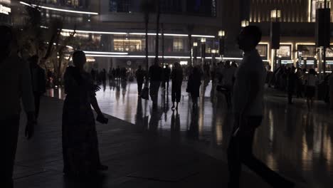 Gente,-Turistas,-Familias-Caminando,-De-Compras-En-El-Centro-Comercial-Dubai-Mall-En-El-Centro-De-Dubai,-Emiratos-Árabes-Unidos,-Con-Rascacielos-Y-Edificios-Iluminados-Por-La-Noche.