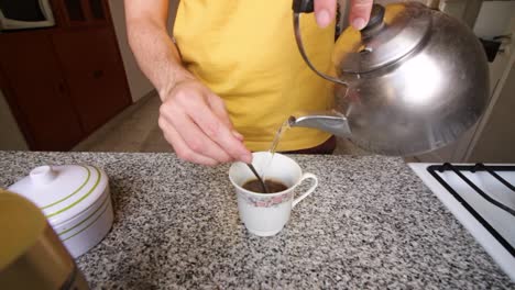 Mann-Gießt-Heißes-Wasser-In-Eine-Tasse,-Um-Instantkaffee-Zuzubereiten