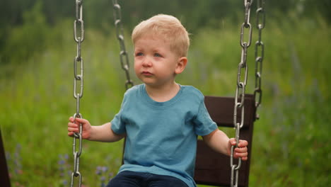 Upset-little-child-sits-on-swings-lost-at-countryside