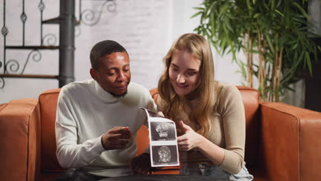 Happy-young-couple-looks-at-ultrasonic-pictures-of-baby