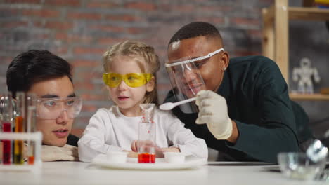 Little-girl-student-adjusts-funnel-and-stirs-material-in-lab