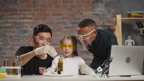 Asian-man-pours-reagent-for-foaming-with-girl-and-teacher