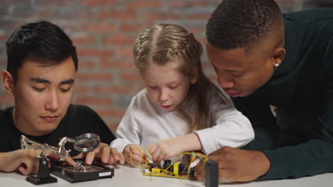 Girl-and-black-engineer-work-with-chip-Asian-guy-fixes-disk