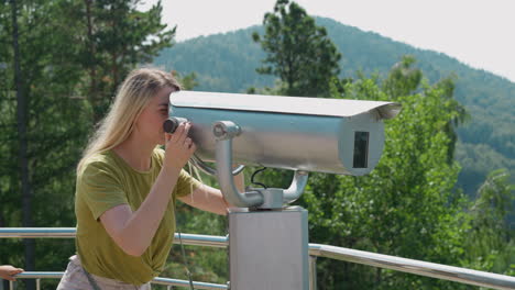 Woman-tourist-looks-through-tower-viewer-on-observation-deck