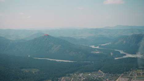 Gleitschirm-Fliegt-über-Großes-Grünes-Tal-Zu-Füßen-Der-Berge