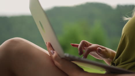 Woman-writes-post-for-blog-page-on-laptop-at-eco-resort