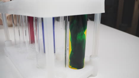Mixing-dark-green-and-yellow-paints-in-test-tube-on-rack