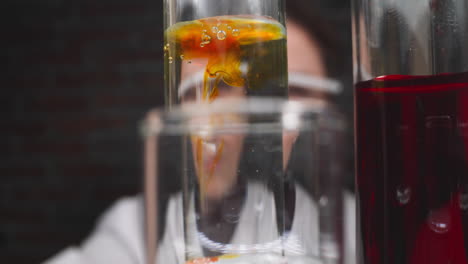 Drops-of-orange-chemical-reagent-fall-down-into-test-tube