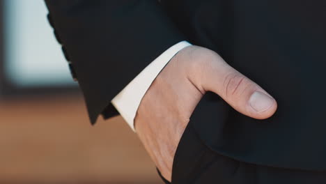 Man-with-gold-wedding-ring-puts-hand-into-trousers-pocket