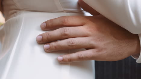 Groom-touches-waist-of-woman-wearing-elegant-white-dress