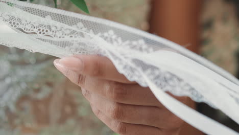 Braut-Im-Hochzeitskleid-Hält-Weiße-Spitzen-Und-Seidenbänder