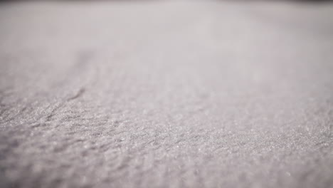 Motion-above-soft-clean-white-fabric-at-bright-light-macro