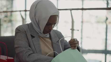 Black-woman-with-hijab-checks-up-purchase-in-shopping-mall
