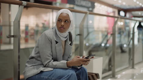 Black-lady-uses-public-wifi-with-mobile-phone-in-mall