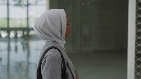 Young-black-woman-with-hijab-looks-around-in-shopping-mall