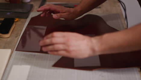 Master-puts-plastic-moulds-onto-leather-in-craft-workshop