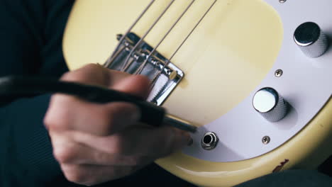 musician-connects-quarter-inch-jack-with-bass-guitar