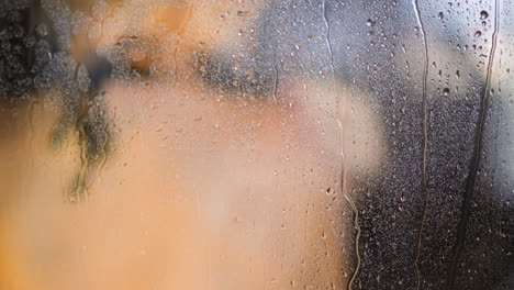 Steamy-shower-glass-wall-with-water-drops-against-woman-back
