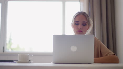 Young-woman-freelancer-works-on-laptop-at-home-office