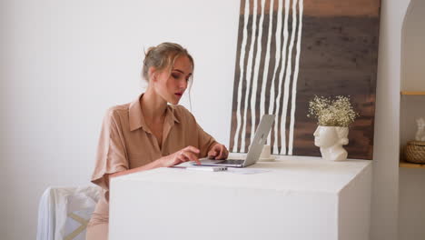 Woman-works-on-laptop-and-numeric-keyword-at-home-office