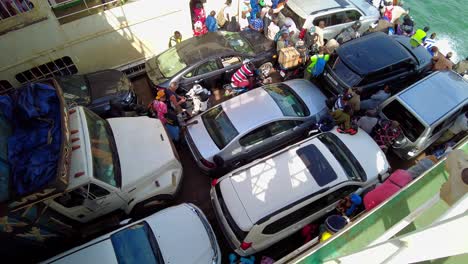 Rotating-tilt-up-view-of-people-and-vehicles-inside-Kunta-Kinteh-ferry-sailing-from-Banjul-to-Barra---Gambia,-West-Africa