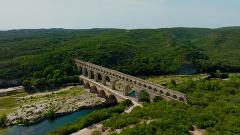 Der-Majestätische-Pont-Du-Gard-In-Okzitanien:-Ein-Sommertag-Inmitten-Von-Touristen,-Die-Baden-Und-Kanufahren-Genießen