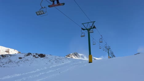 Two-seater-chair-lift-on-a-quiet-day-at-a-Ski-field-underneath-blue-skies