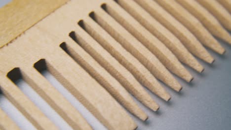 motion-along-handmade-wooden-comb-lying-on-grey-surface