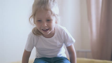 little-girl-in-t-shirt-jumps-in-playpen-in-children-room