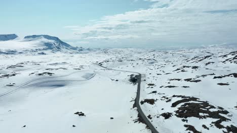 Road-going-through-endless-snowy-landscape-at-Sognefjellet-mountain-pass-in-Norway