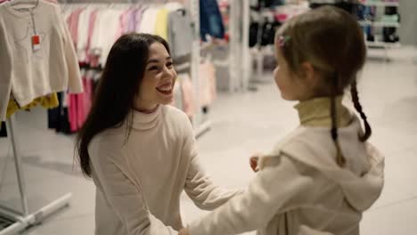 Young-beautiful-mother-hugs-a-little-daughter-in-shopping-mall
