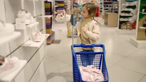 Little-girl-at-shoe-store-with-shopping-cart