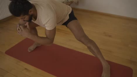 Young-man-performing-stretch-exercise-at-home