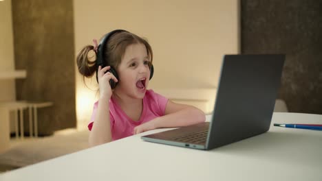 Hübsches-Mädchen-Mit-Kopfhörern-Sitzt-Zu-Hause-Und-Hört-Musik-Auf-Dem-Laptop-Und-Spielt-Ein-Computerspiel