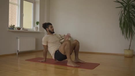 Young-man-stretching-spine,-bending-imitating-bridge-exercise