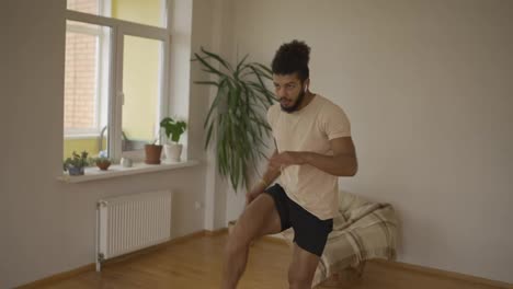 Athletic-fit-man-doing-forward-lunge-exercises-at-home-with-minimalist-interior