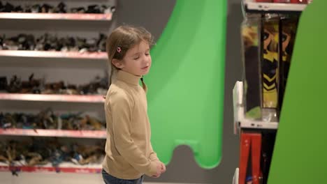 Kleines-Mädchen-Ist-Aufregend-Bei-Der-Auswahl-Von-Spielzeugkisten-Im-Einkaufszentrum
