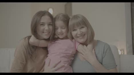 Beautiful-granny,-mother-and-daughter-are-looking-at-camera-and-smiling