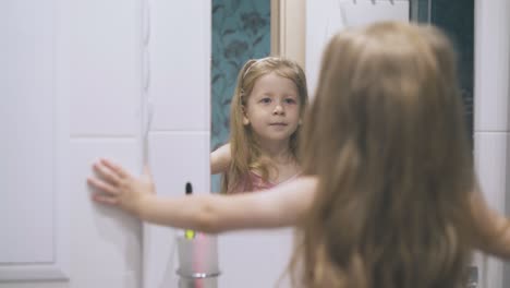 Junge-Dame-Blickt-In-Den-Spiegel-Und-Posiert-Im-Hellen,-Modernen-Badezimmer