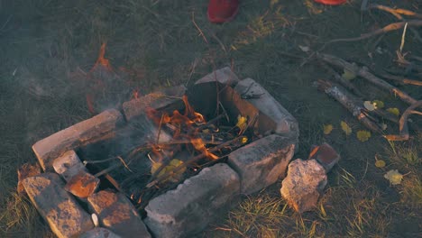 burning-bonfire-on-brown-grass-of-camp-at-autumn-sunset