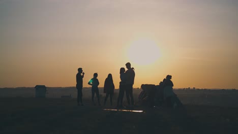 Silhouetten-Von-Touristen,-Die-Bei-Sonnenuntergang-Zeit-Im-Zelt-Verbringen