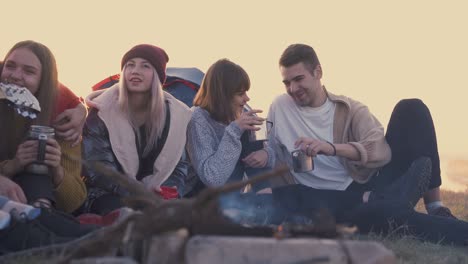 tourists-drink-tea-at-burning-bonfire-in-evening-slow-motion
